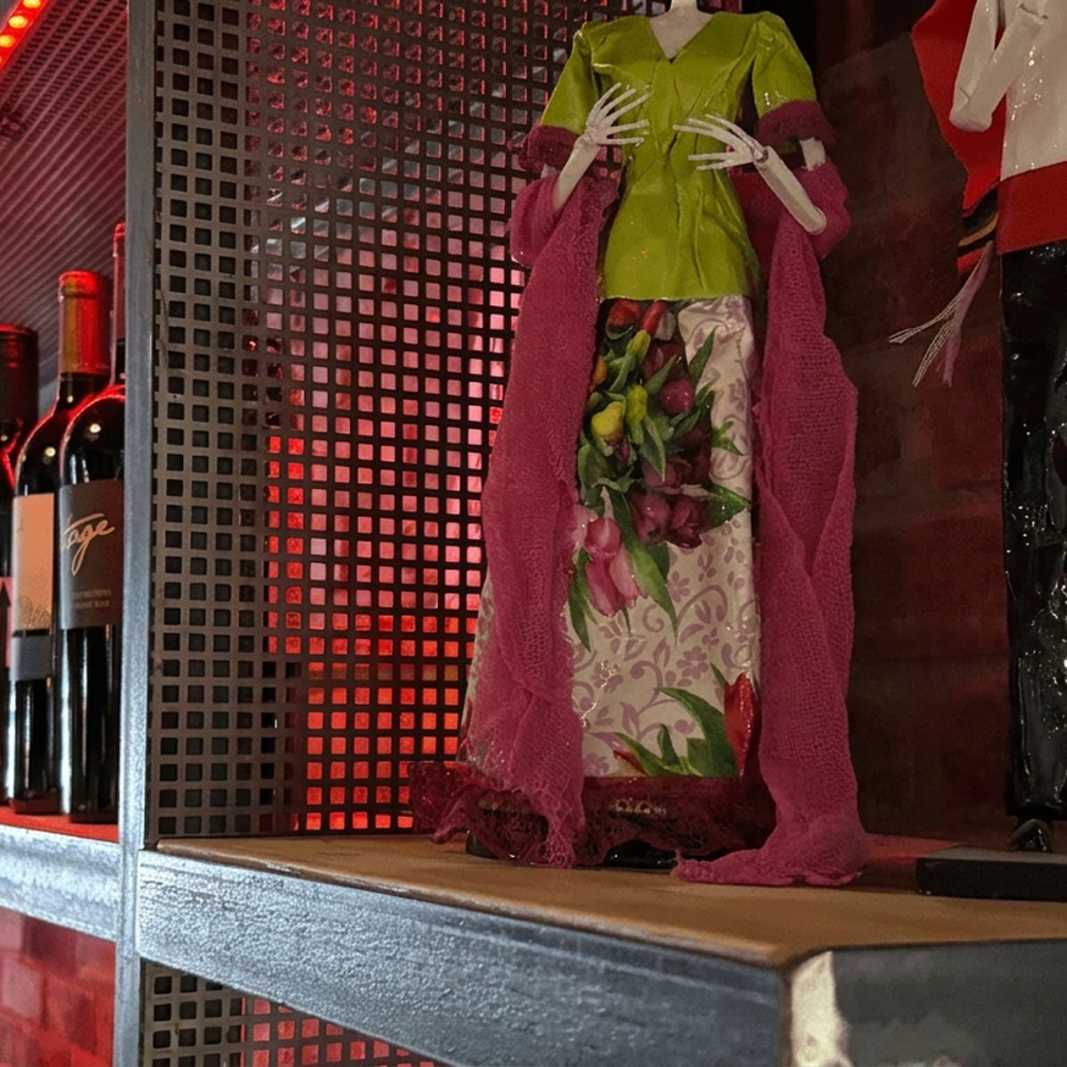 Colorful mannequins stand beside wine bottles on industrial shelving illuminated by red lighting.